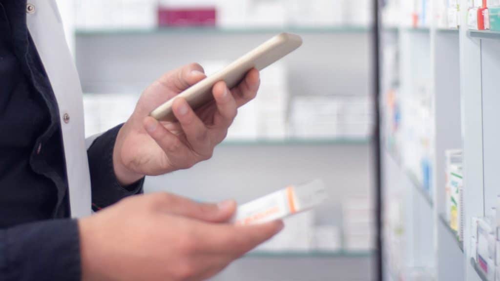 man performing quality inspection scan of drug box for